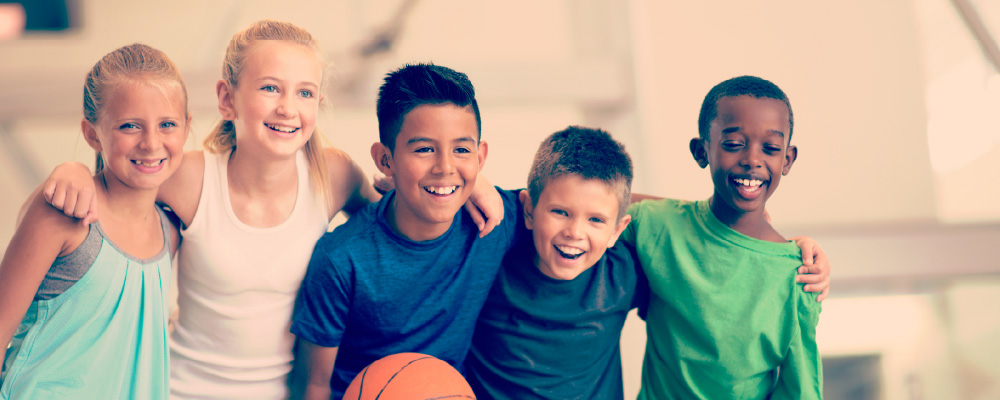 A group of smiling kids playing basketball